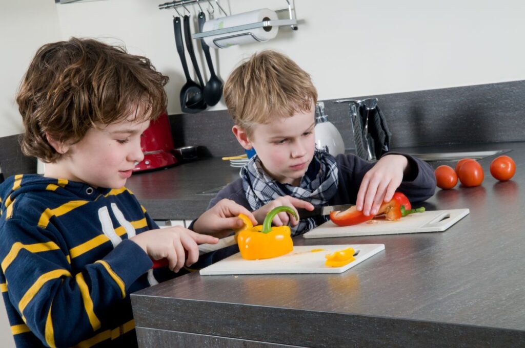 two boys cutting capsicum