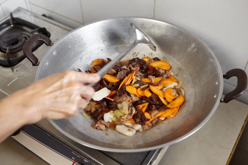 person stir frying vegetables