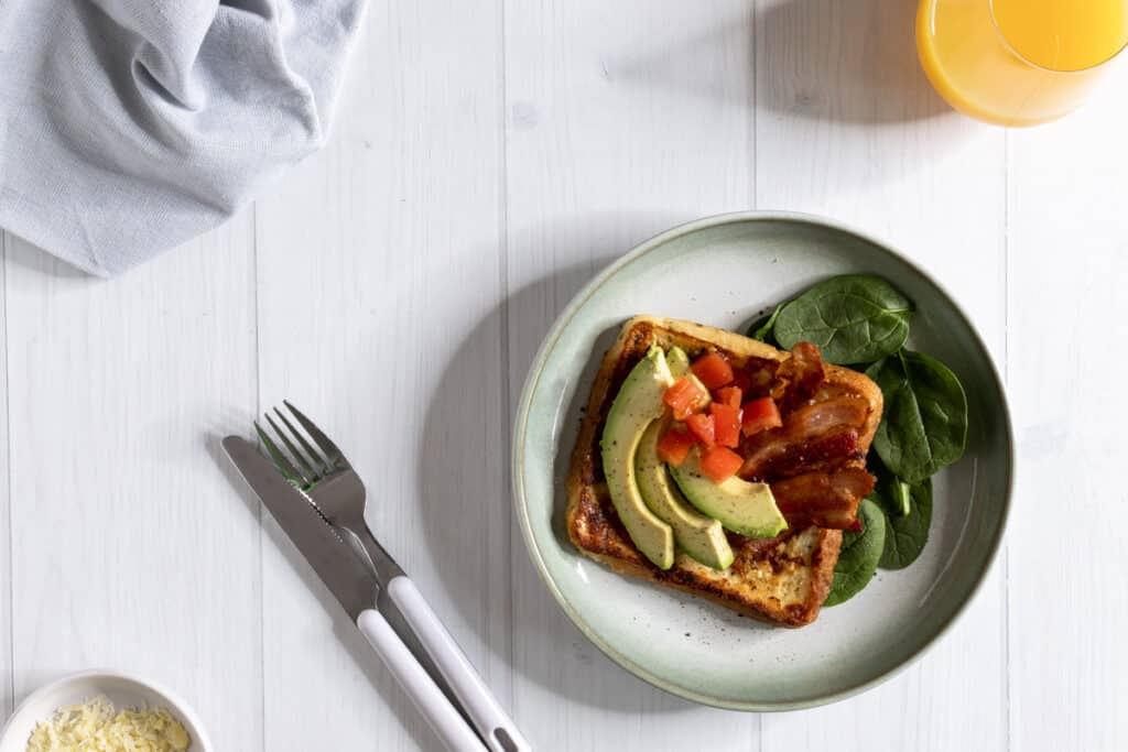 savoury french toast with avocado, tomato, bacon, served with juice