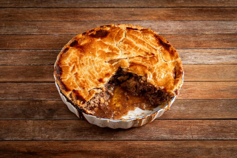 old fashioned, slow cooked beef pie on a wooden background