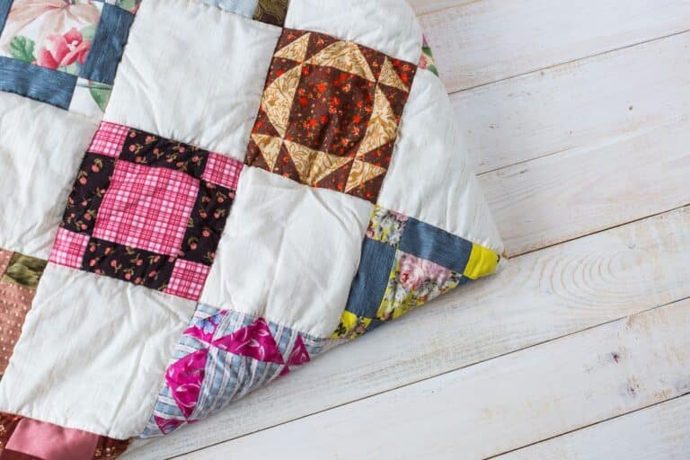 scrappy patchwork quilt, folded, on wooden background