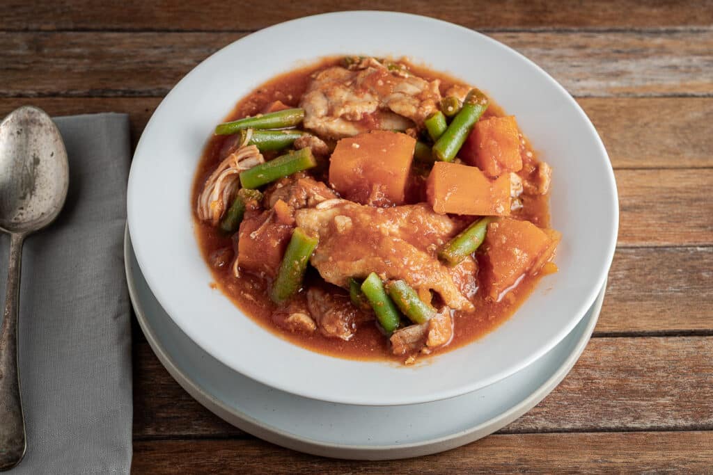 slow cooker chicken and sweet potato stew on a wooden background