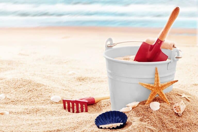 bucket and spade in the sand at the beach with sea shells