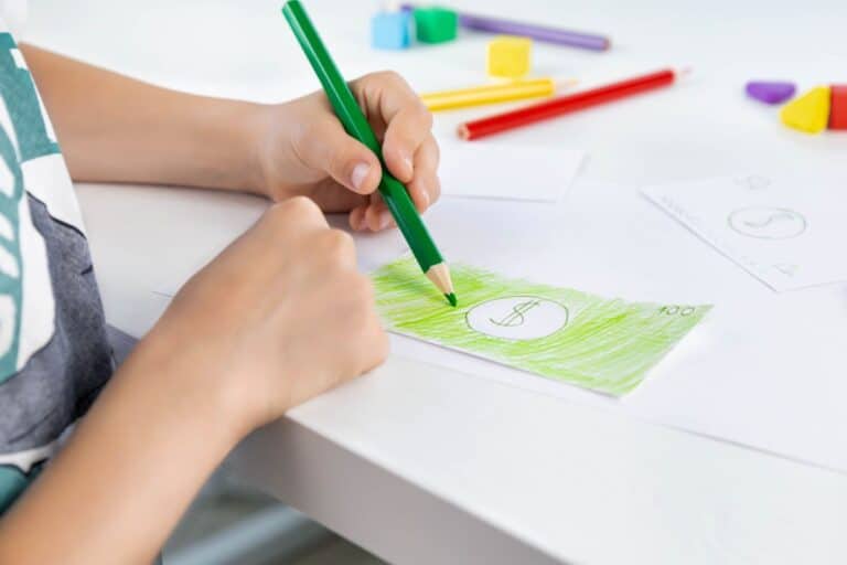 child colouring in play money