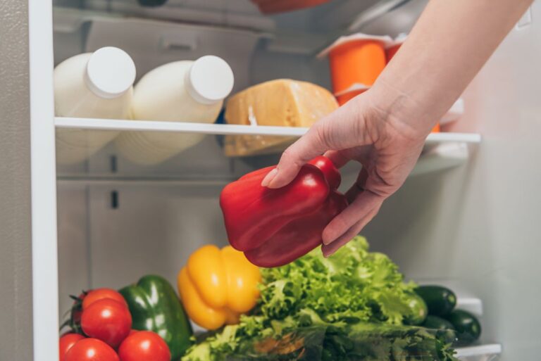 woman removing bell pepper from the fridge