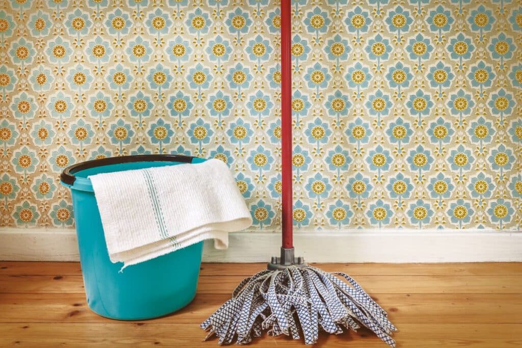 mop and bucket infront of wall papered wall