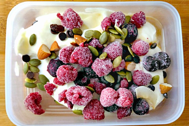 yoghurt topped with frozen berries and trail mix