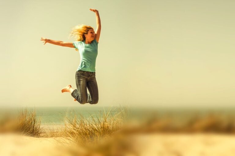 woman jumping in the air at the beach