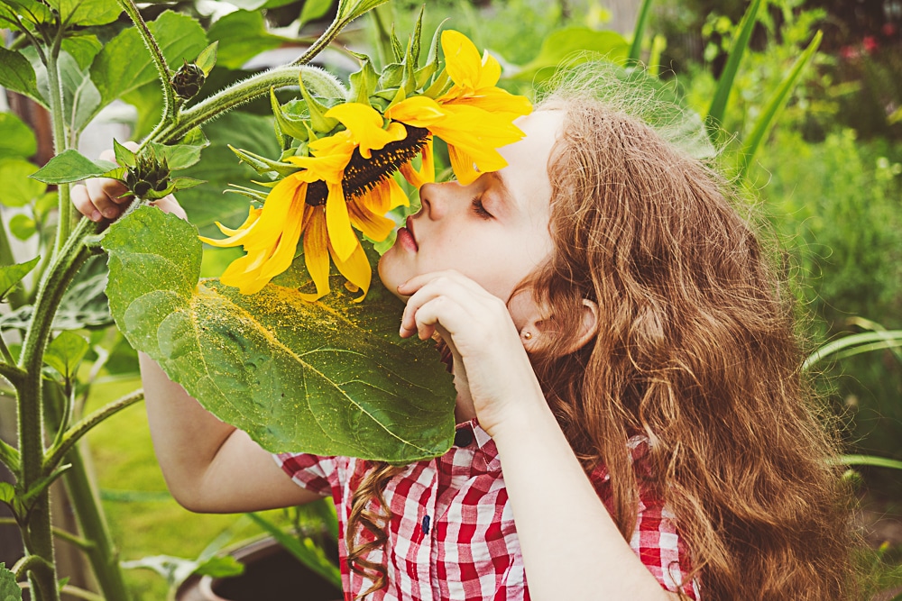 girl enjoying simple pleasures of smelling flowers