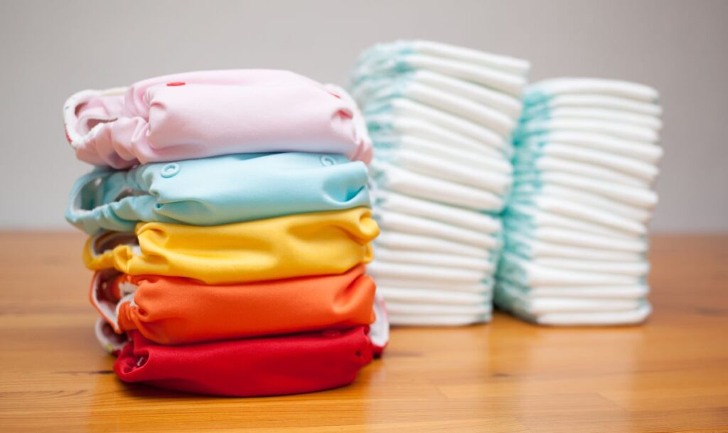stack of cloth nappies and stack of disposable nappies/diapers