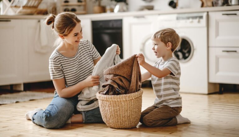 mother and son folding washed towels as part of their household routine