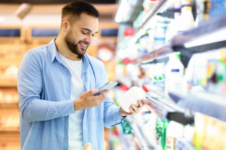 man comparing details of grocery item on phone