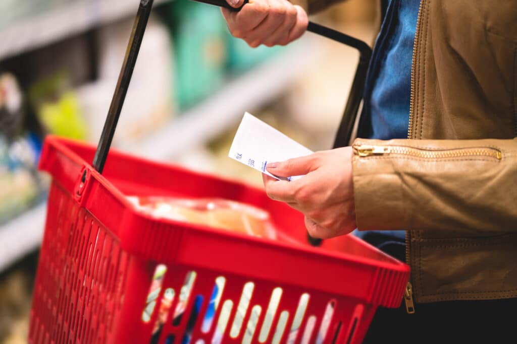 woman holding shopping basket reading grocery list