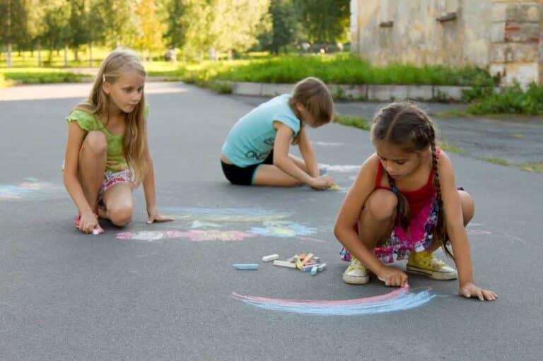 kids drawing on the pavement with chalk