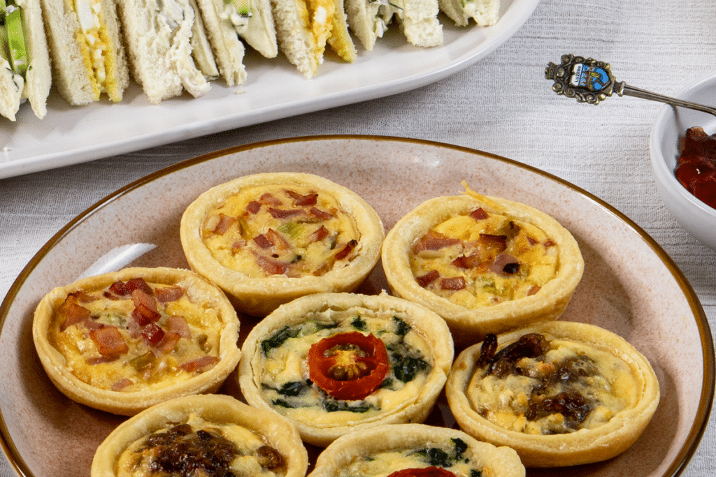 a plate of homemade mini quiches for high tea