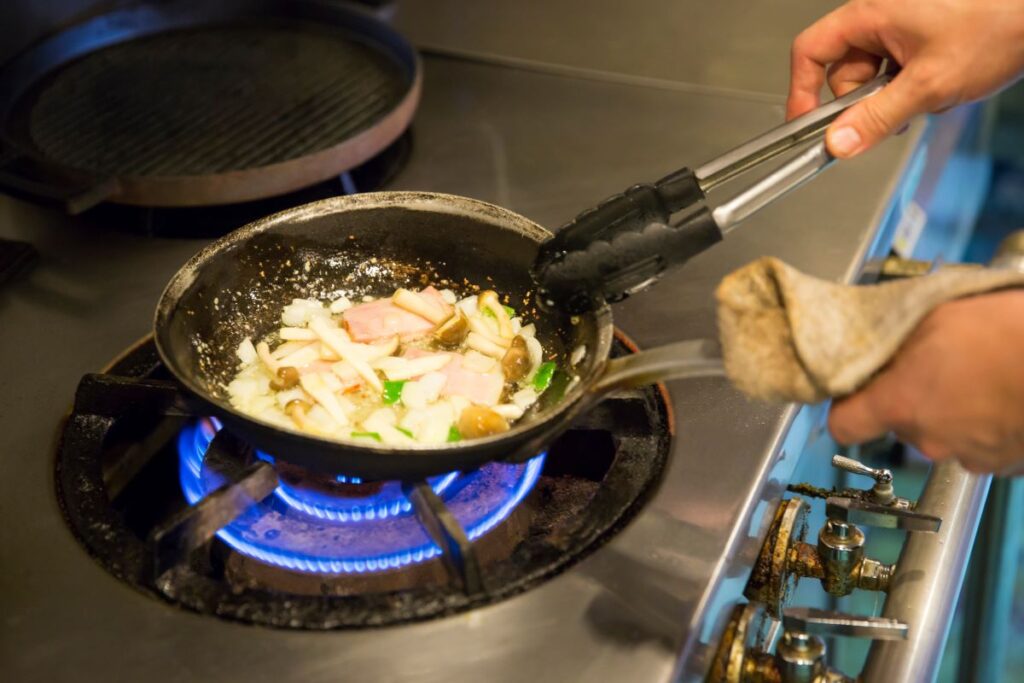 person sauteing mushrooms