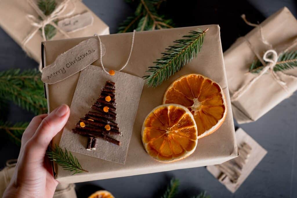 woman holding eco friendly gift with pine and dried orange decorations