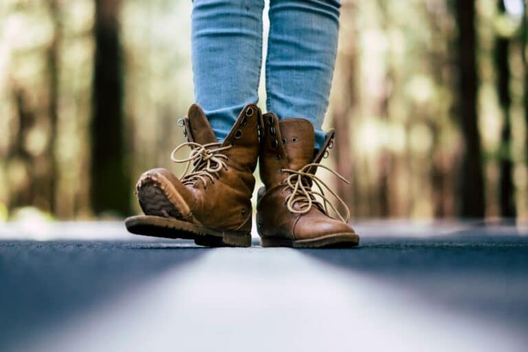 woman wandering in forest with broken shoe representing spend more to save more
