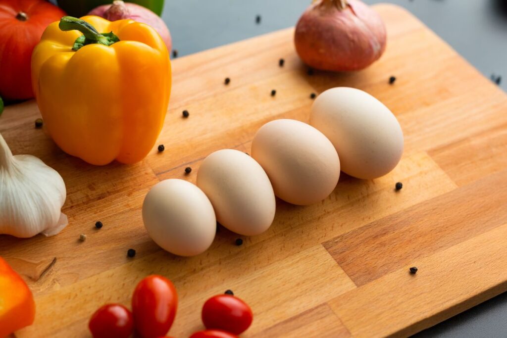 eggs on cutting board with a variety of vegetables